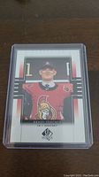 Front view of Brady Tkachuk rookie hockey card in clear protective case.