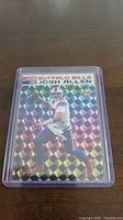 Josh Allen rookie football card with holographic prismatic background in protective plastic case.