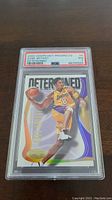 Front view of the 2000 Hoops Hot Prospects Kobe Bryant basketball card graded PSA 7 in protective PSA case showing player in Lakers uniform with 'Determined' design