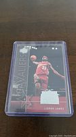 Front of LeBron James rookie basketball trading card in protective case showing player in Cleveland Cavaliers uniform.