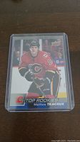 Photo of Matthew Tkachuk rookie hockey card showing front of card with player image and branding, encased in plastic sleeve for protection.