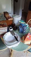 Full lot displayed on table with cook books, dishes, containers, CD storage and other items