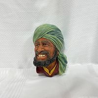 Front and angled view of vintage Bosson chalkware head showing detailed facial features, green turban, and maroon clothing.