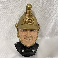 Front view of the Bosson chalkware Victorian firefighter head with detailed gold helmet and black uniform collar.