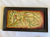Full view of the rectangular framed painting print on leather showing two colorful birds perched on branches with foliage in the background, highlighting the overall artwork and frame condition
