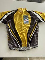 Yellow, black, and grey short sleeve cycling top with front zipper and Canadian Cancer Society logo laid flat showing front side