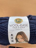 Close-up of the Lion Brand Wool-Ease Thick & Quick yarn label showing the brand and product name