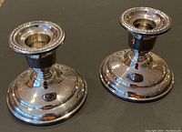 Close-up photo of the pair of small silver-plated candlesticks with beaded edging around the top rim.