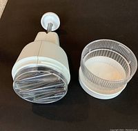 Zyliss manual food chopper disassembled showing chopping blades and clear plastic bowl