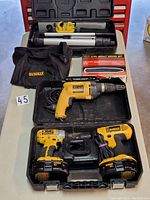 Image showing Dewalt impact driver, drill, charger, batteries, and screw tool in a black case alongside a laser set in its case and 8-piece bit set.