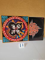 Front view of the vinyl record partially out of the black sleeve showing KISS logo and the colorful front sleeve with band members artwork.