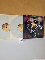 Front view of KISS Alive double vinyl LP album with gatefold sleeve and both records visible in paper inner sleeves.