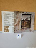Vinyl LP gatefold sleeve front cover showing a man carrying a load of sticks, some peeling and wear around edges, includes inner lyric sleeve visible.