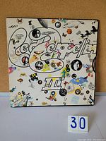 Front view of the Led Zeppelin III album gatefold cover with colorful artistic graphics and logo.