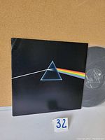 Front cover of Pink Floyd The Dark Side of the Moon gatefold album showing prism design and rainbow light beam.