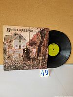 Front cover of Black Sabbath vinyl record sleeve and partially visible yellow label vinyl record.