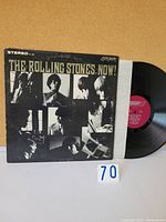 Front cover of The Rolling Stones Now! vinyl album sleeve showing black and white collage of band photos and album title.