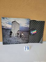 Front of album cover with The Who band members standing near concrete monolith; inner sleeve with colorful face design visible.