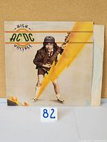 Front cover of AC/DC High Voltage vinyl LP showing Angus Young illustration with lightning bolt and AC/DC logo.
