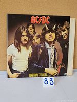 Front cover of AC/DC Highway to Hell vinyl LP showing all band members, with Angus Young in center wearing horns and blue jacket.
