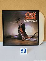 Vinyl LP album Blizzard of Ozz by Ozzy Osbourne with cover sleeve and white vinyl disc visible.