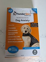 Front box photo showing ThunderShirt branding, usage info and picture of dog wearing the shirt.
