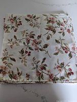 Stack of floral cotton napkins showing fabric pattern and finished edges, folded square.
