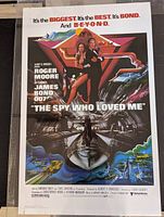 Front view of colorful illustrated one sheet movie poster from 1977 James Bond film The Spy Who Loved Me showing James Bond and other action elements.