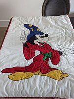 Full view of 1993 child-sized quilt featuring Mickey Mouse as a sorcerer in a red robe and blue wizard hat.