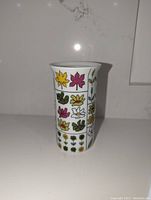 Front view of the porcelain vase showing the colorful floral grid pattern.