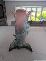 Front view of vintage Hull Pottery unicorn vase with pink glaze upper portion and green base with sculptured unicorn attached.