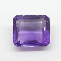 Natural rectangular cut purple amethyst gemstone placed on white background showing full gemstone and facets.