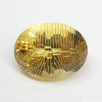 Front view of the oval honeycomb cut citrine gemstone showing the detailed honeycomb faceting and yellow-orange color.