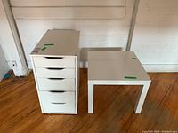 Photo showing white 5-drawer filing cabinet beside the white square side table on wooden floor against white wall