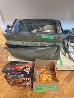 Open cooler bag with visible BBQ cover and three partial boxes of HotHands hand warmers along with loose hand warmers.