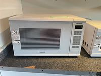Front view of Panasonic white microwave showing the door and control panel