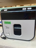 Front view of Tru Red shredder showing power and feed control buttons and a transparent window to view shred contents.