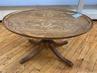 Full top view of the oval hardwood side table showing carved edge and surface wood grain.