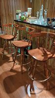 Three stools in front of countertop and wood-paneled wall