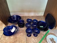 Overview of all blue glass dish set components arranged on floor.