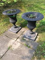 Both urns side by side on grass with concrete pavers beneath