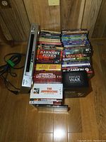 Photo of the silver Sony DVD player standing vertically next to a stack of DVDs.