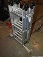 Folded aluminum multi-function ladder with visible rungs and locking hinges.
