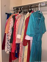 Hanging women's clothing on a rod showing various dresses and garments in light and bright colors