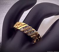 Oblique front view of ring showing diagonal diamond-set stripes and nugget texture