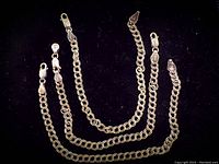 Three sterling silver chain bracelets displayed side by side on black velvet showing length and clasp type