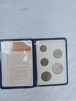 Front side of the coin holder showing the coins and an informational card about Britain's first decimal coins.