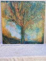 Full frontal photo of the textured abstract tree painting on square canvas placed against a white backdrop.