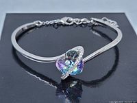 Photo of a silver-tone bracelet with a multi-faceted Austrian crystal heart centerpiece and small clear crystal accent