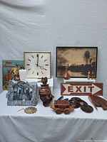 Wide view of the lot showing door stop along with clock, paintings, and assorted decorative items.